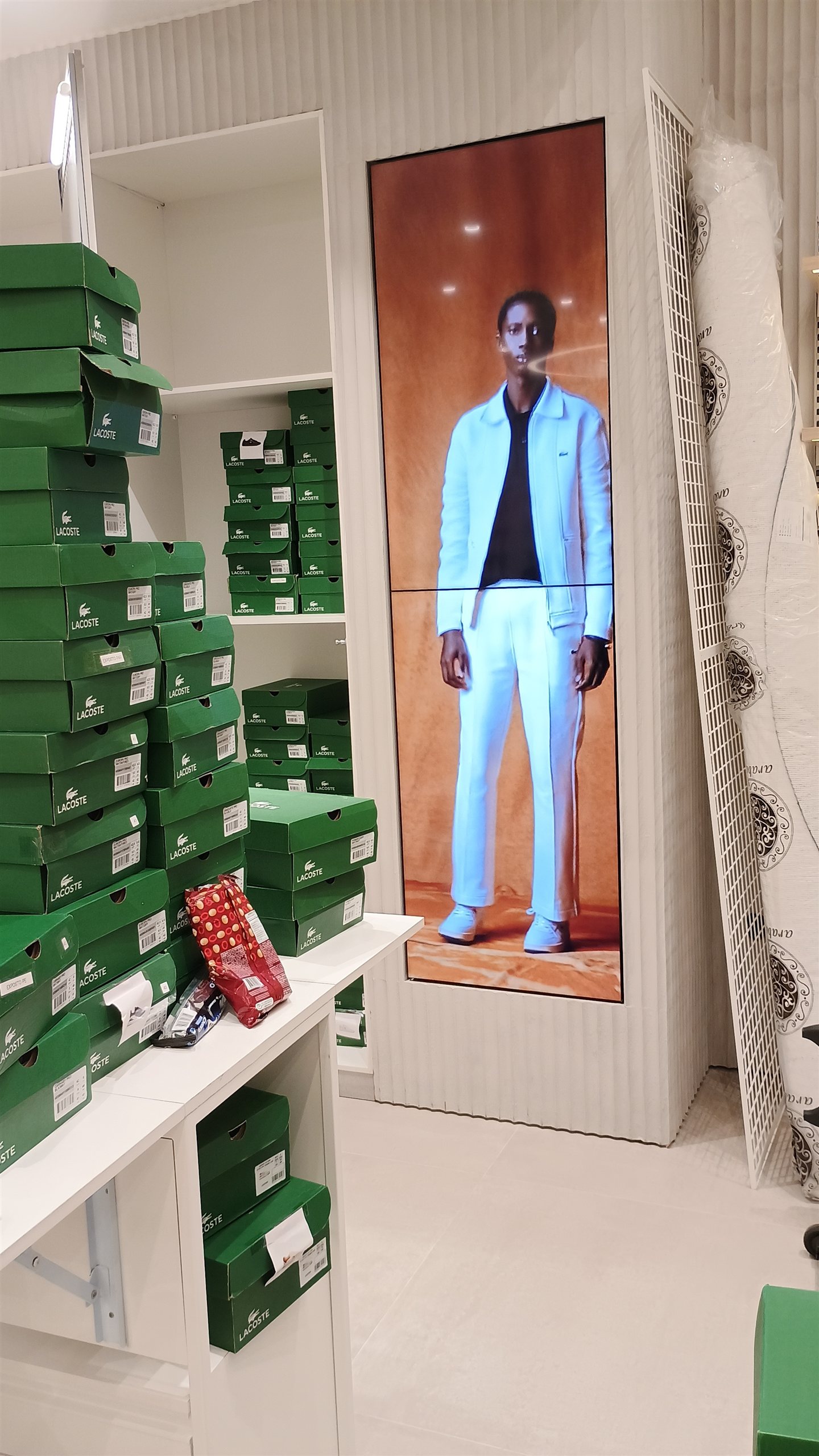 VideoWall vertical 1x2 exibindo campanha de moda durante a montagem da loja Lacoste em Londrina