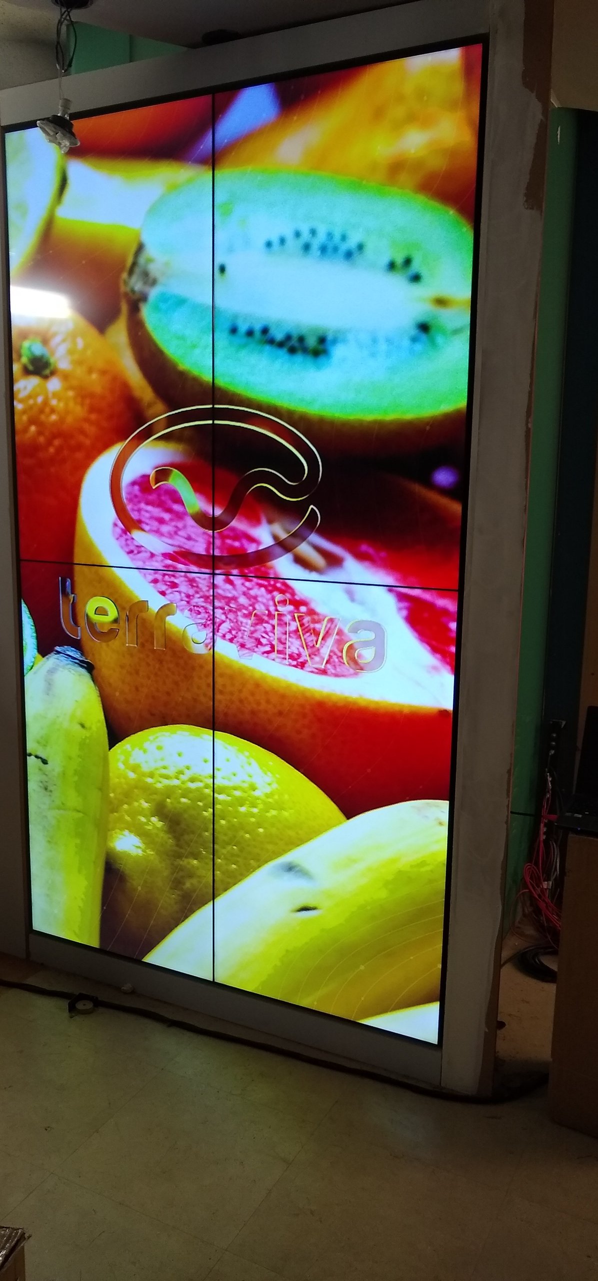 VideoWall 2x2 vertical em nicho com imagem em alta saturacao e as juntas finas entre os quatro monitores visiveis